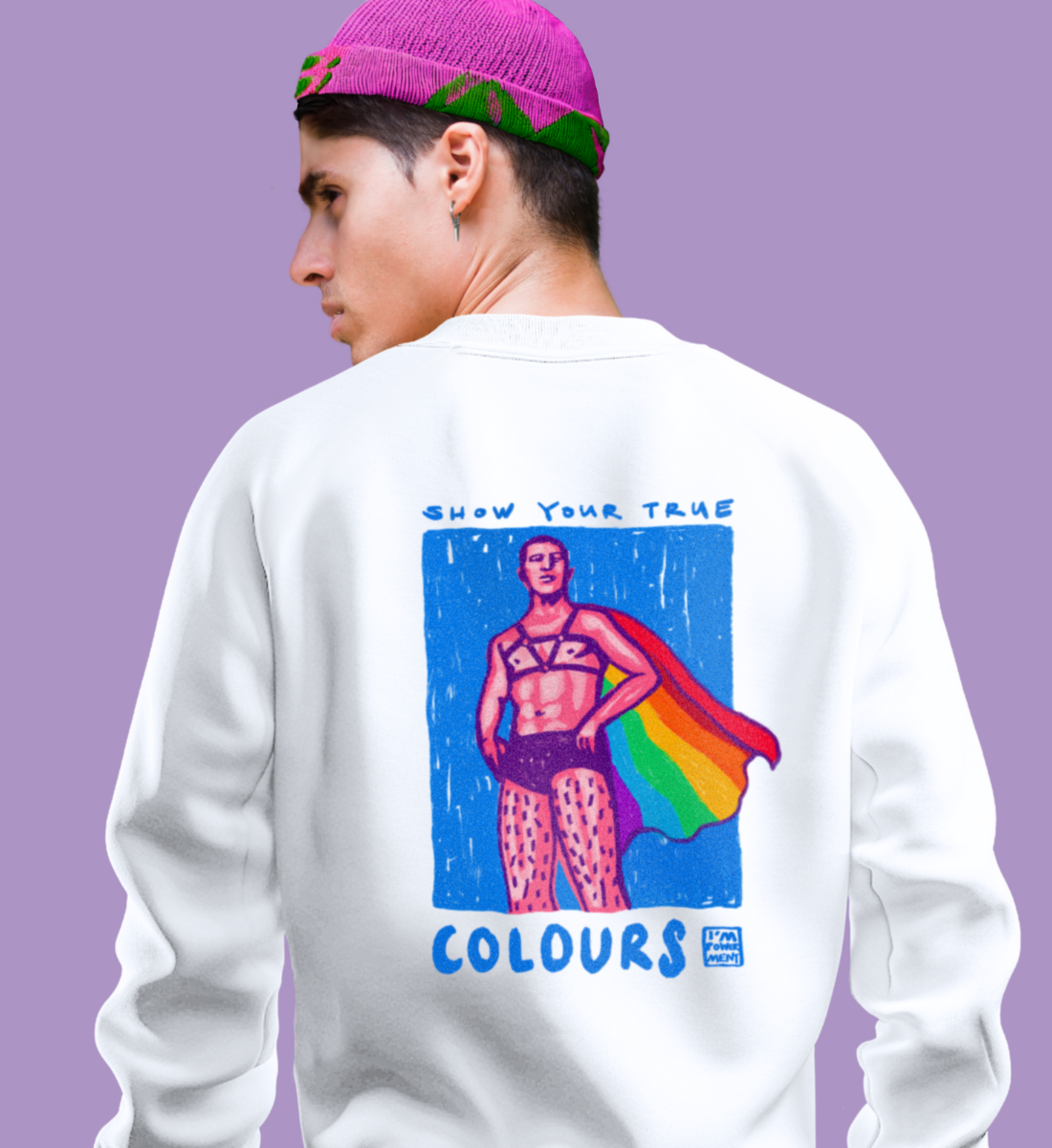 Mann trägt Unisex Sweater mit Rückenprint “Show your true colours”. Darauf zu sehen ist ein Mann im Superhelden Stil mit Leder-Harness und Regenbogenflagge als Cape.